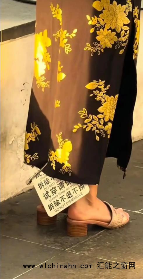 女子穿着带有巨大吊牌旗袍街头拍照